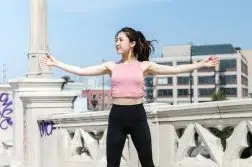 Woman Wearing Pink Crop Top Jumping on Concrete Floor