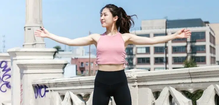 Woman Wearing Pink Crop Top Jumping on Concrete Floor