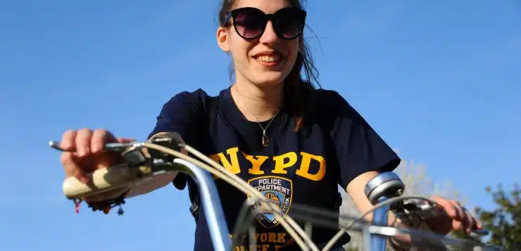 woman in black and yellow crew neck t-shirt riding bicycle during daytime