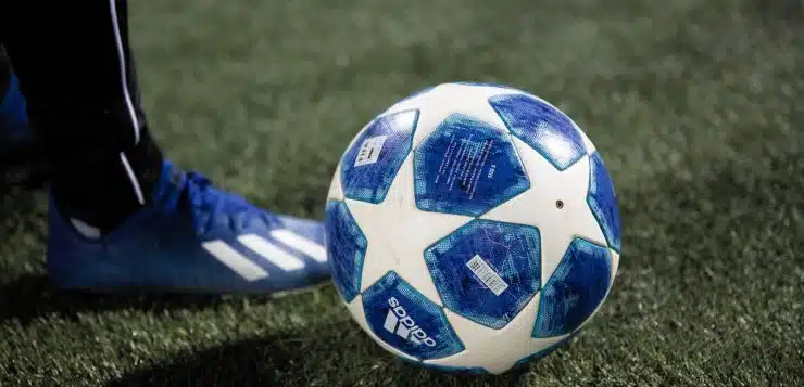 blue and white soccer ball on green grass field